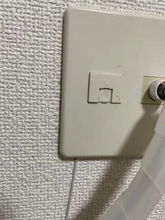 マンションの壁に設置されたVDSL方式の電話線モジュラージャックとスプリッターの写真
